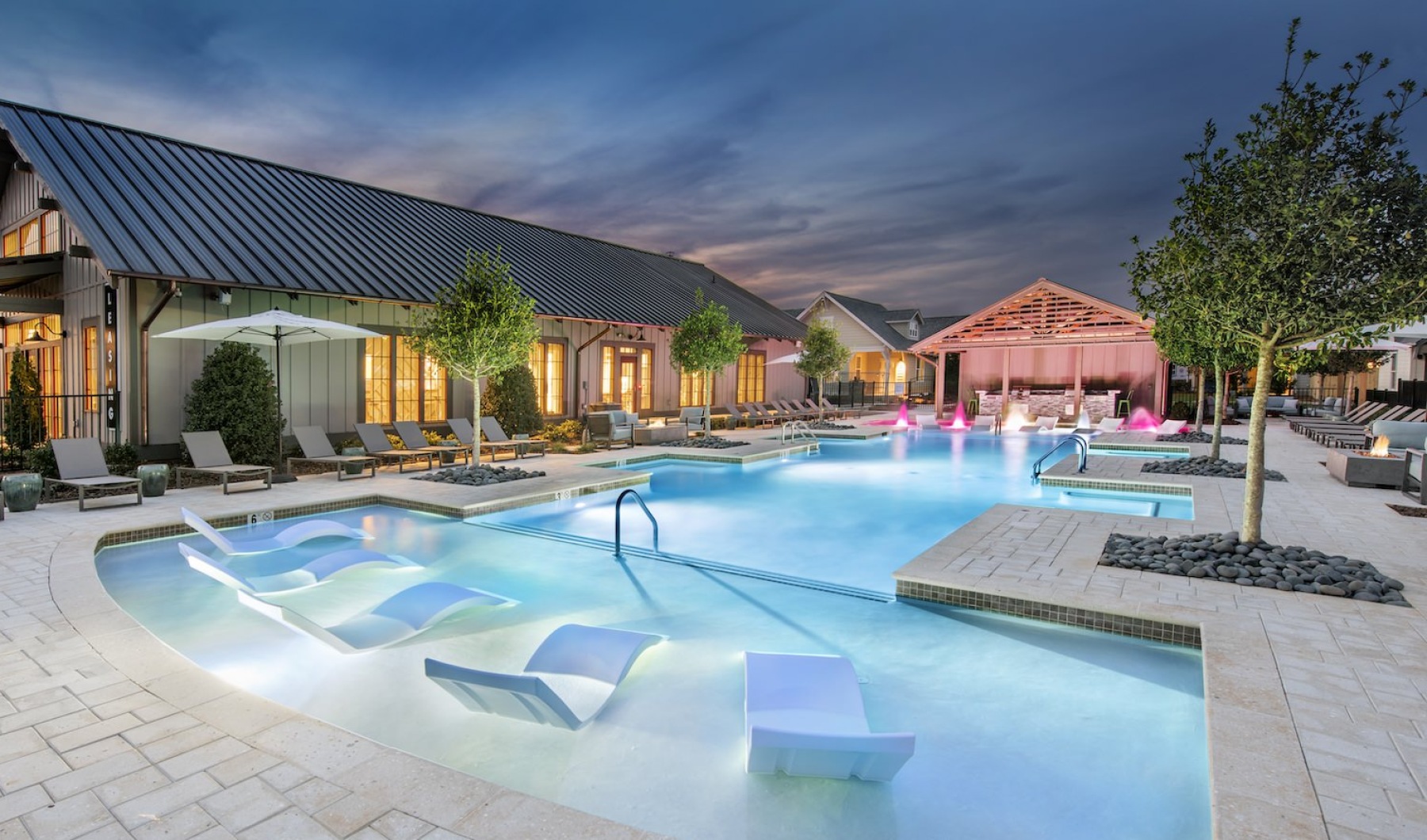 Large sparkling blue pool with a large deck and lounge chairs 